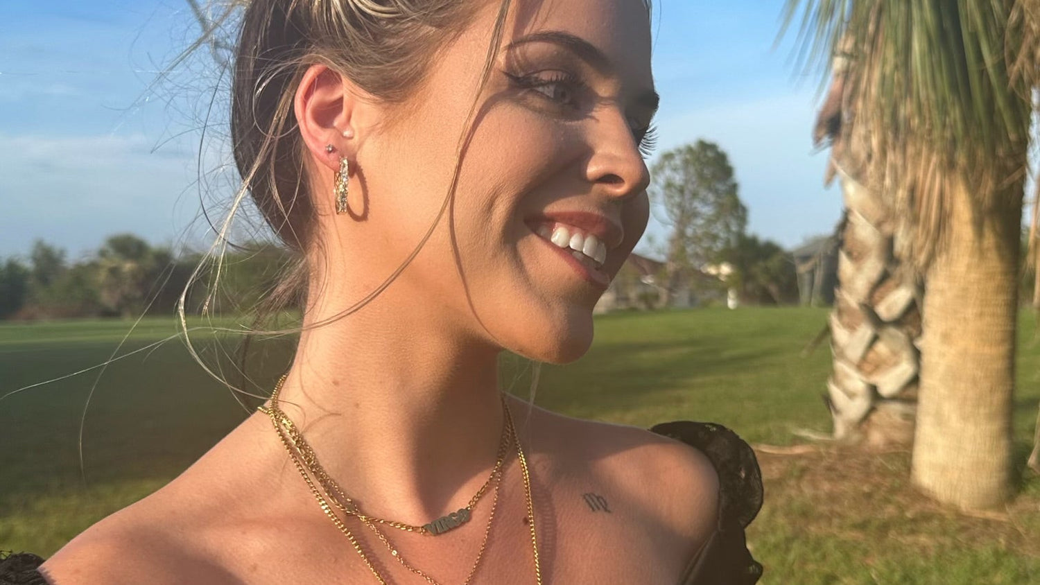 Woman outdoors with palm trees and clear sky