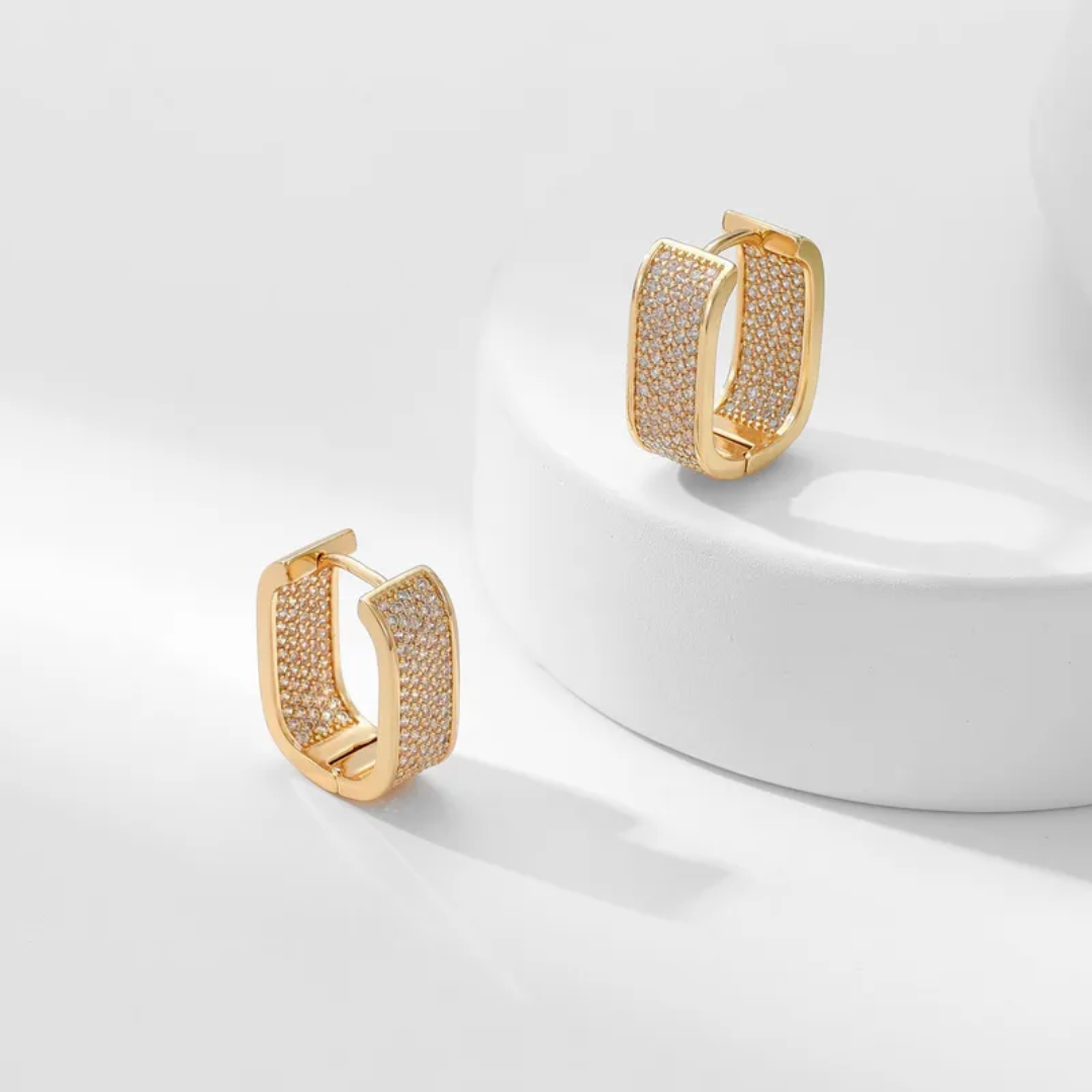 Gold hoop earrings with gemstones on a white background