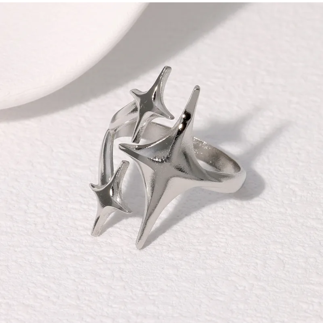 Silver ring with star-like design on a white background