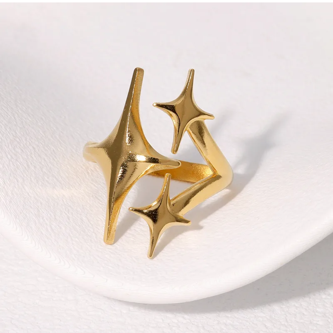 Gold spike ring on a white plate with a white background