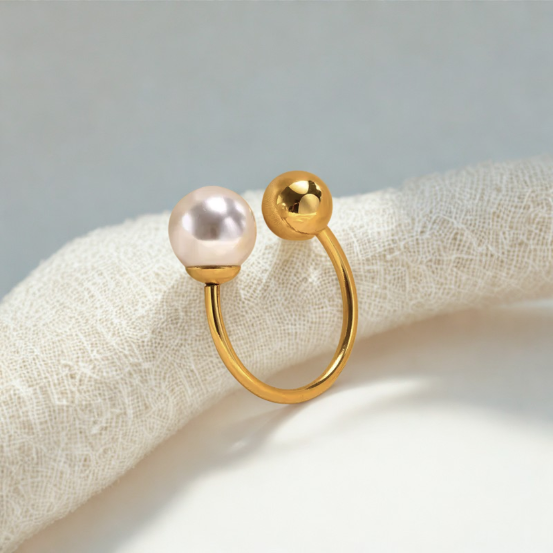 Gold ring with a pearl on a textured fabric background