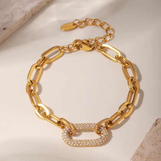 Gold chain bracelet with a clasp on a light background