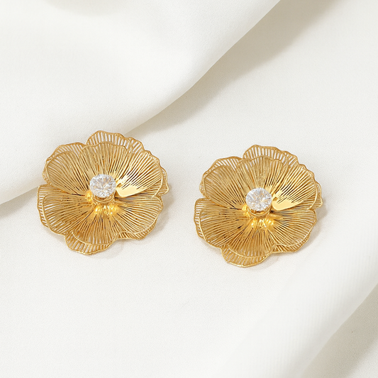 Pair of gold floral earrings on a white background