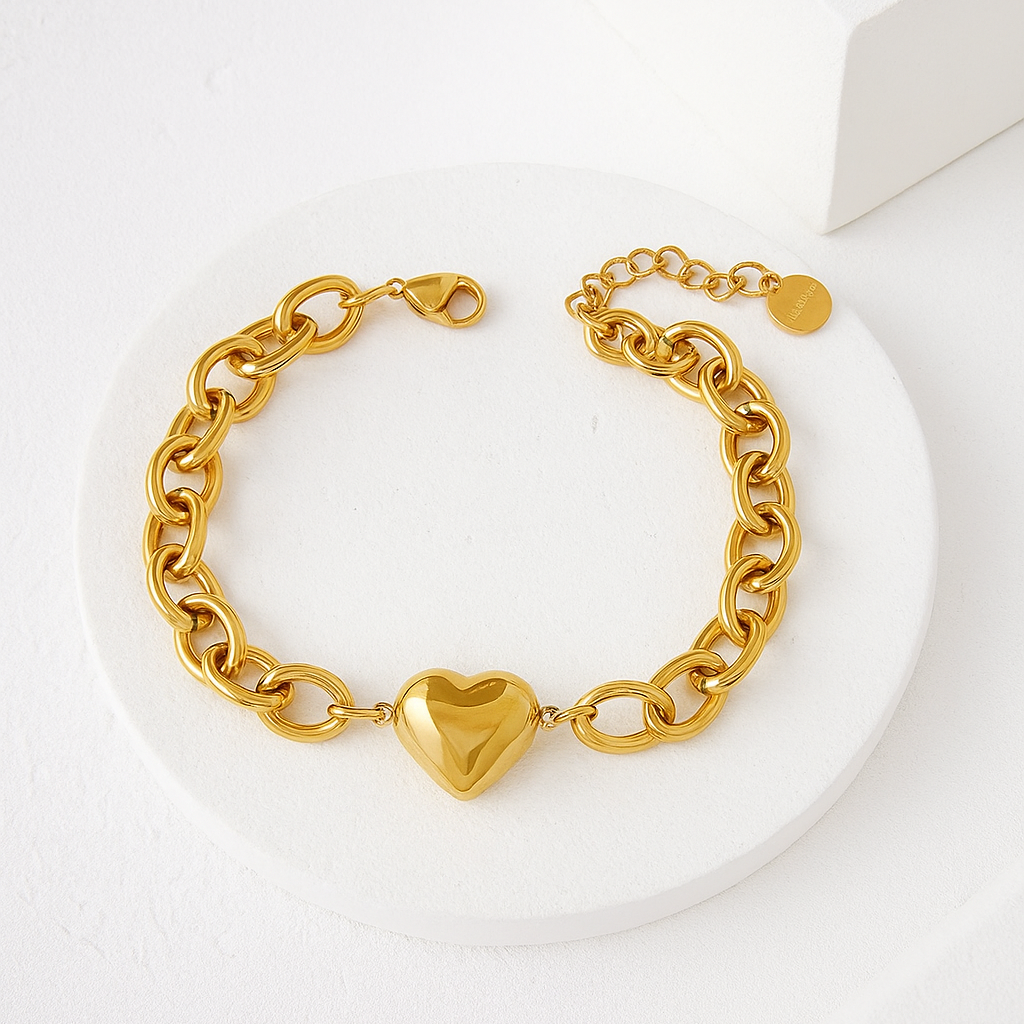 Gold chain bracelet with a heart-shaped clasp on a white background