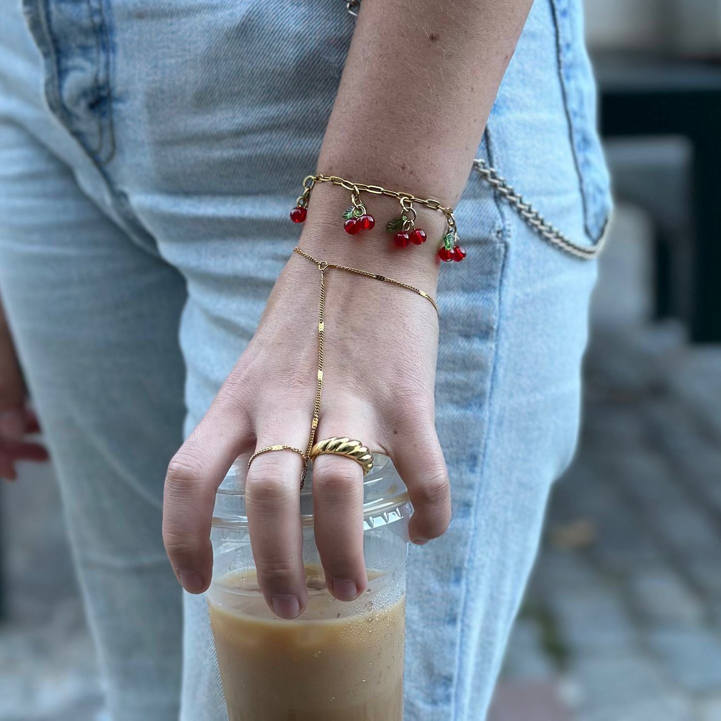 Person holding a glass of iced coffee with a blurred background