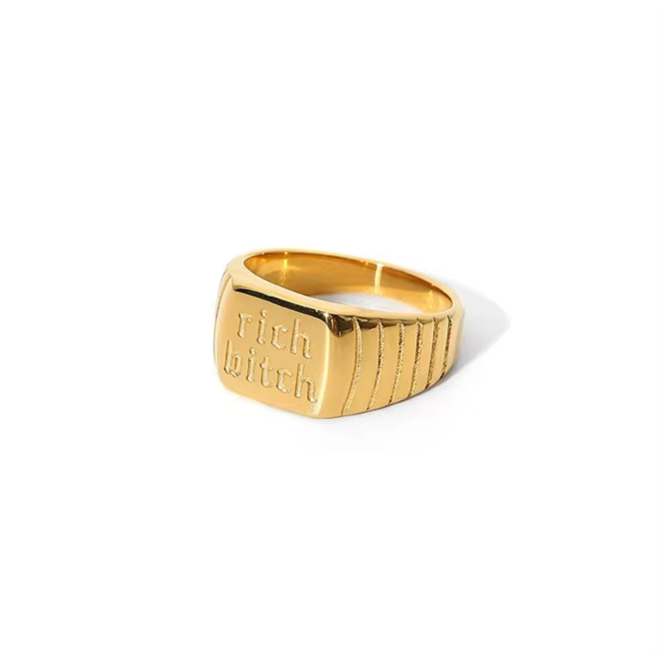 Gold ring with 'rich bitch' engraving on a white background