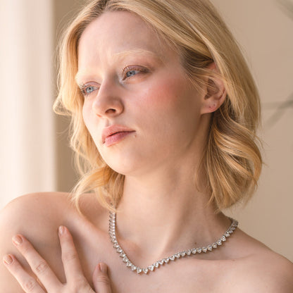 Woman wearing a pearl necklace with a neutral background