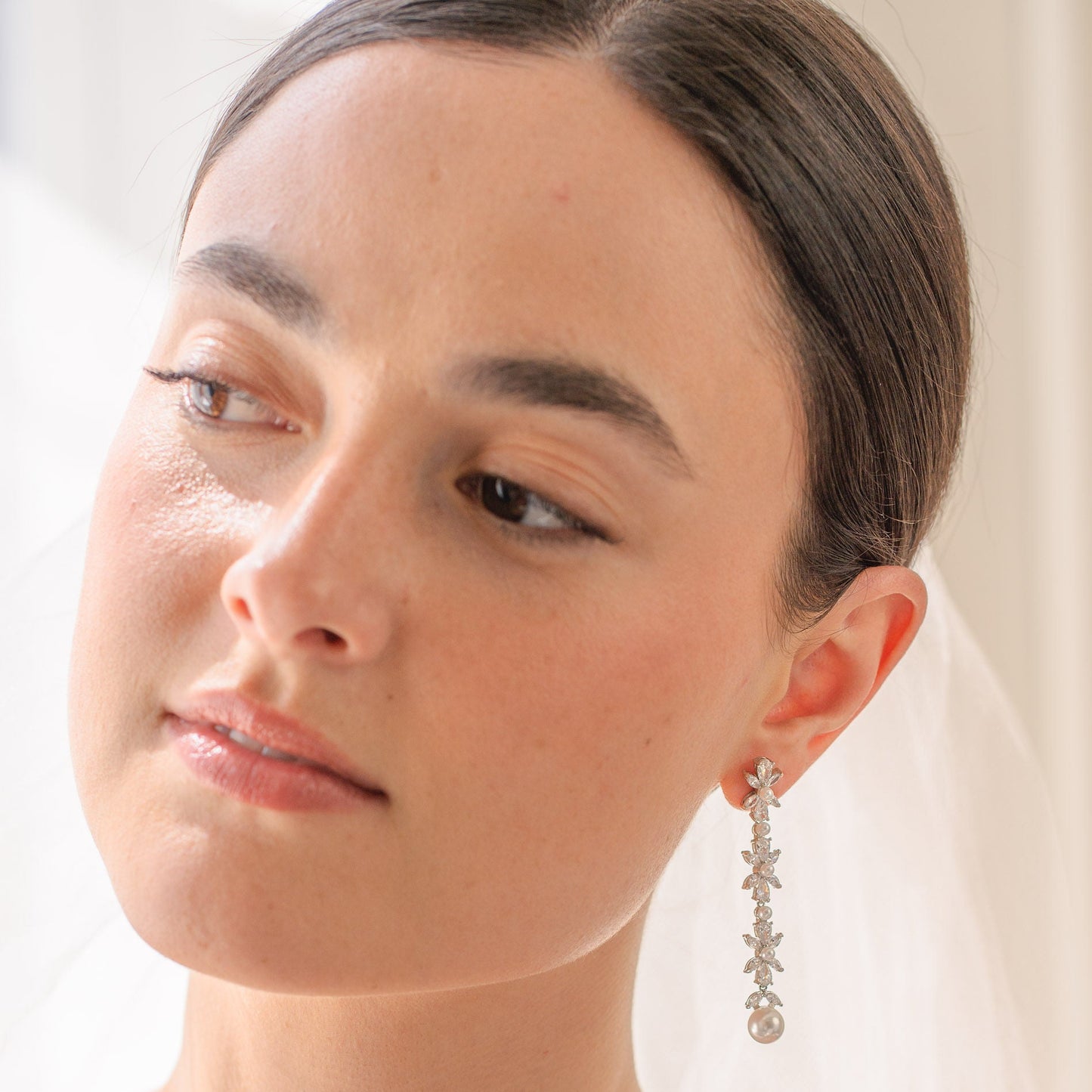 Woman wearing a silver earring with a white background
