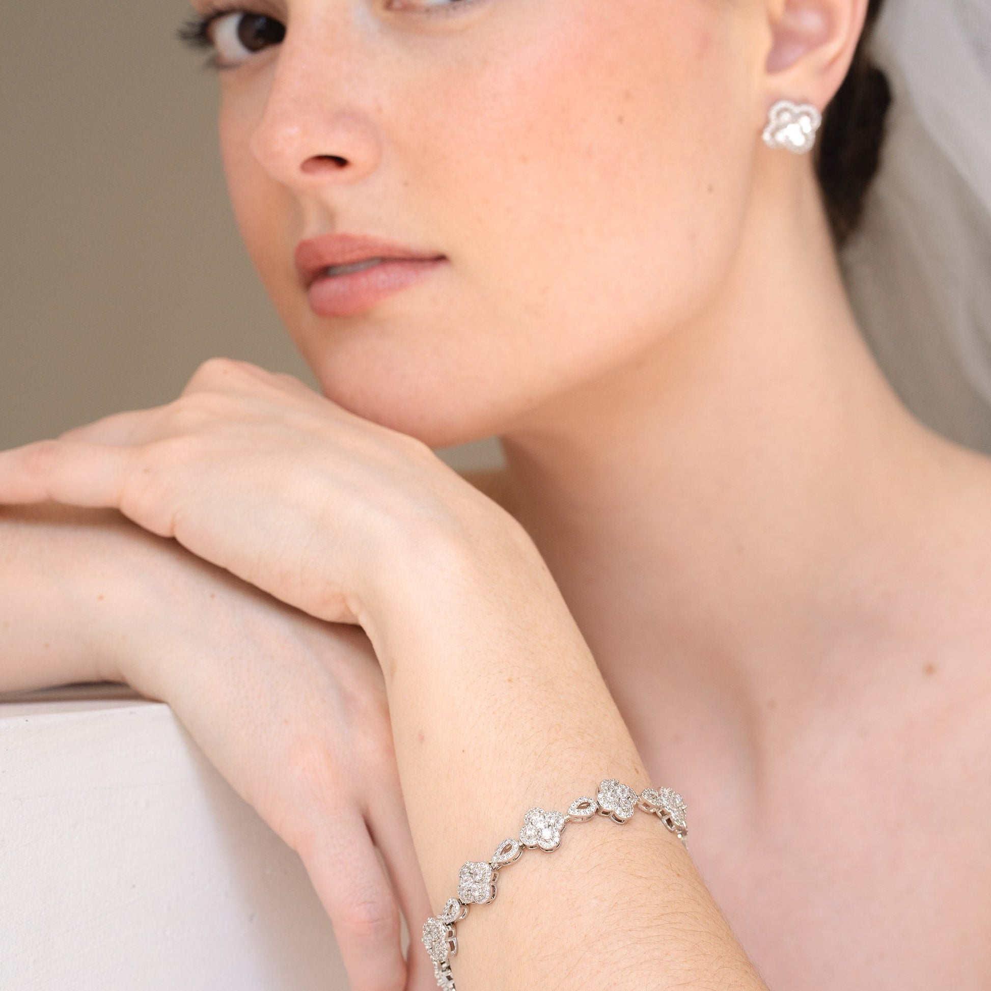 Close-up of a bride wearing a silver bracelet with floral designs.
