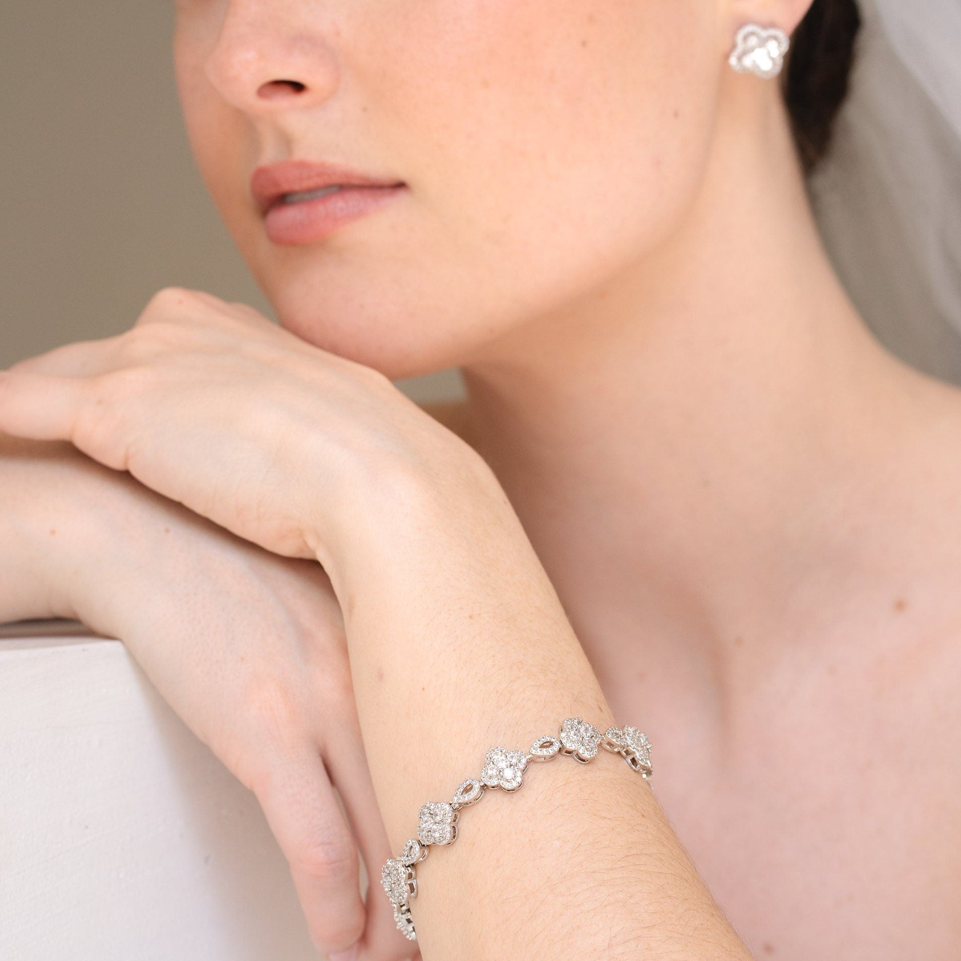 Close-up of a bride wearing a silver bracelet with floral designs.