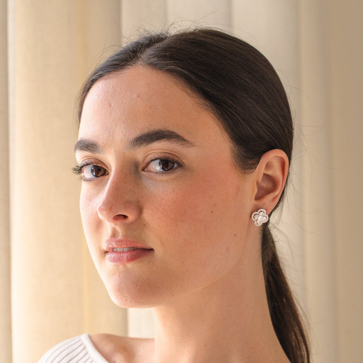 Woman wearing a white sweater with a neutral background