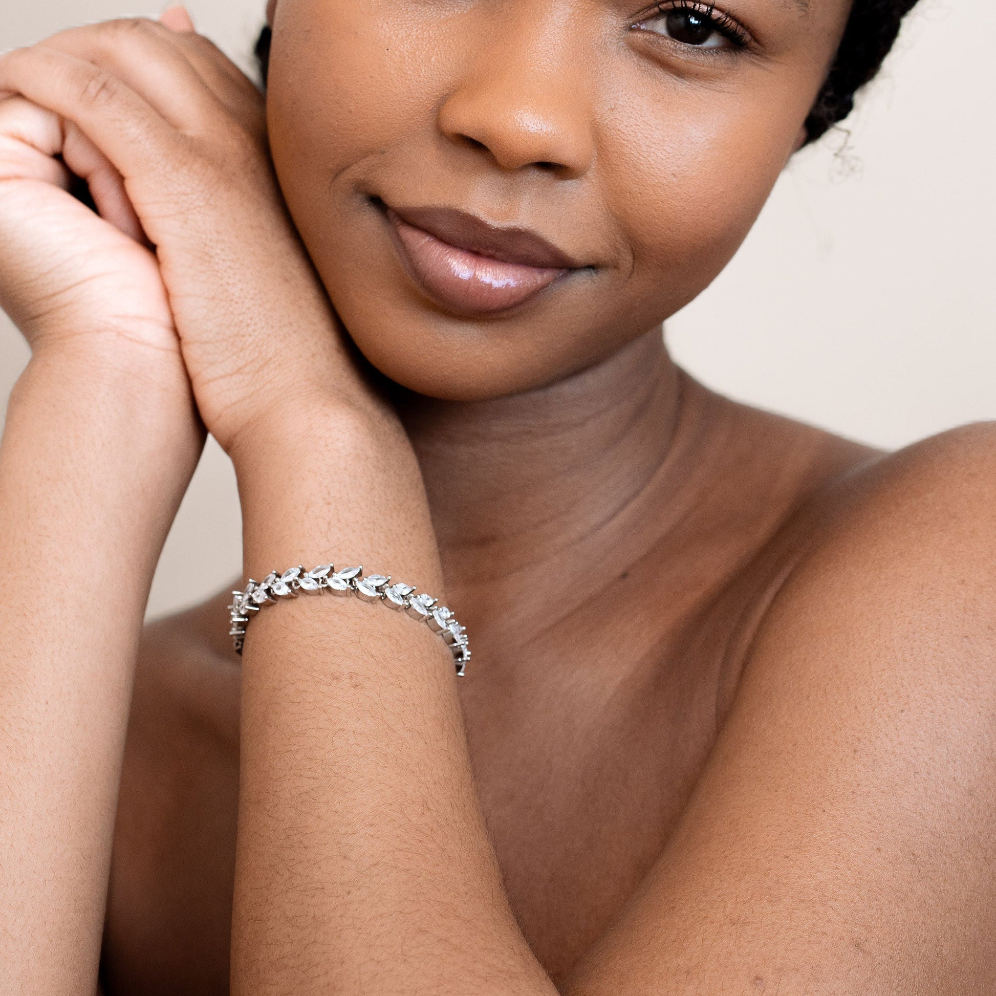 Woman wearing a silver bracelet on a plain background