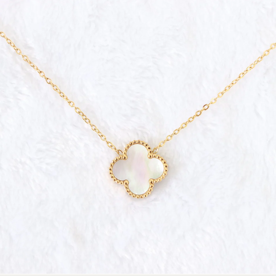 Gold necklace with a heart-shaped pendant on a white background