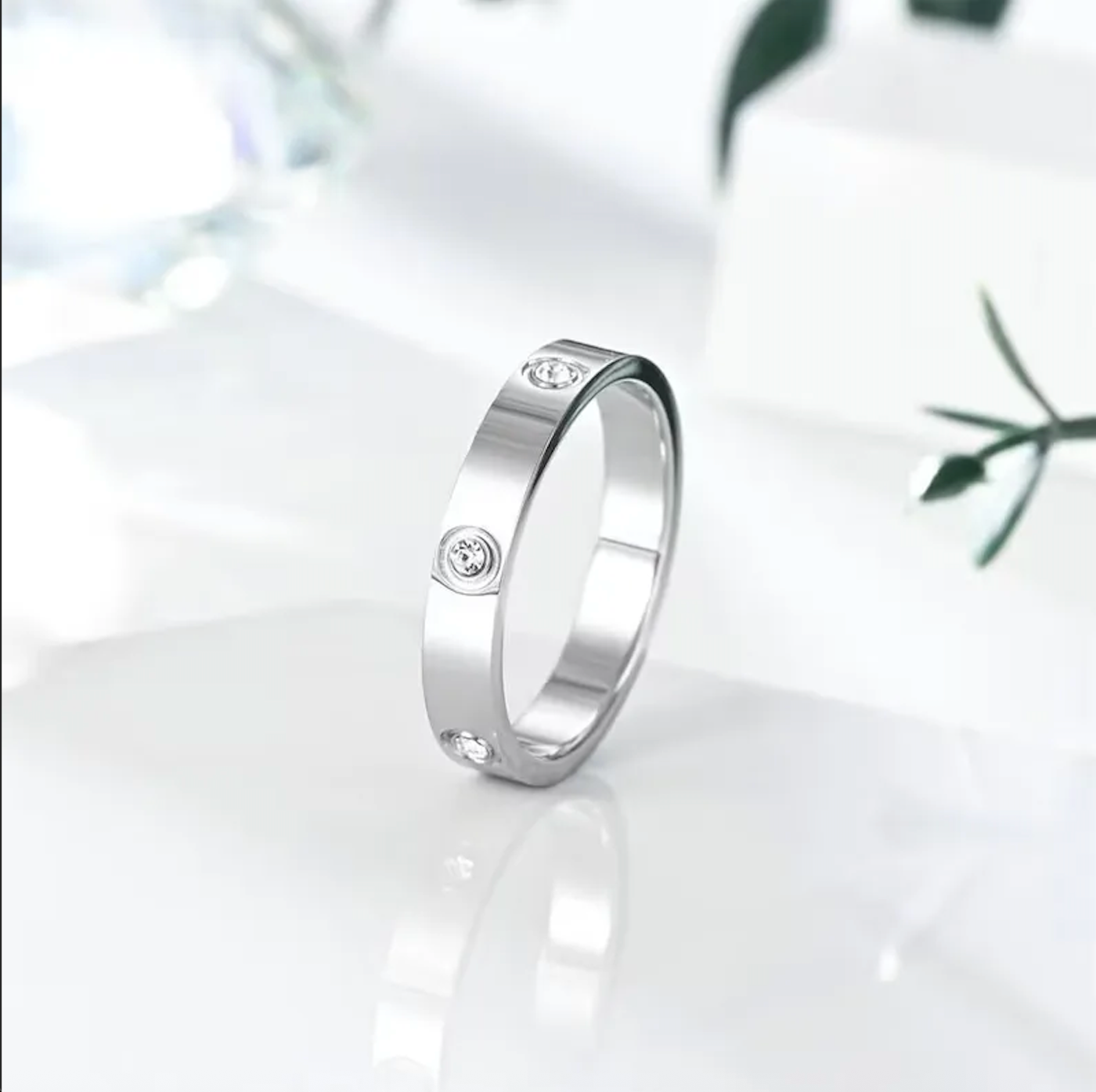 Silver ring with small diamonds on a white background