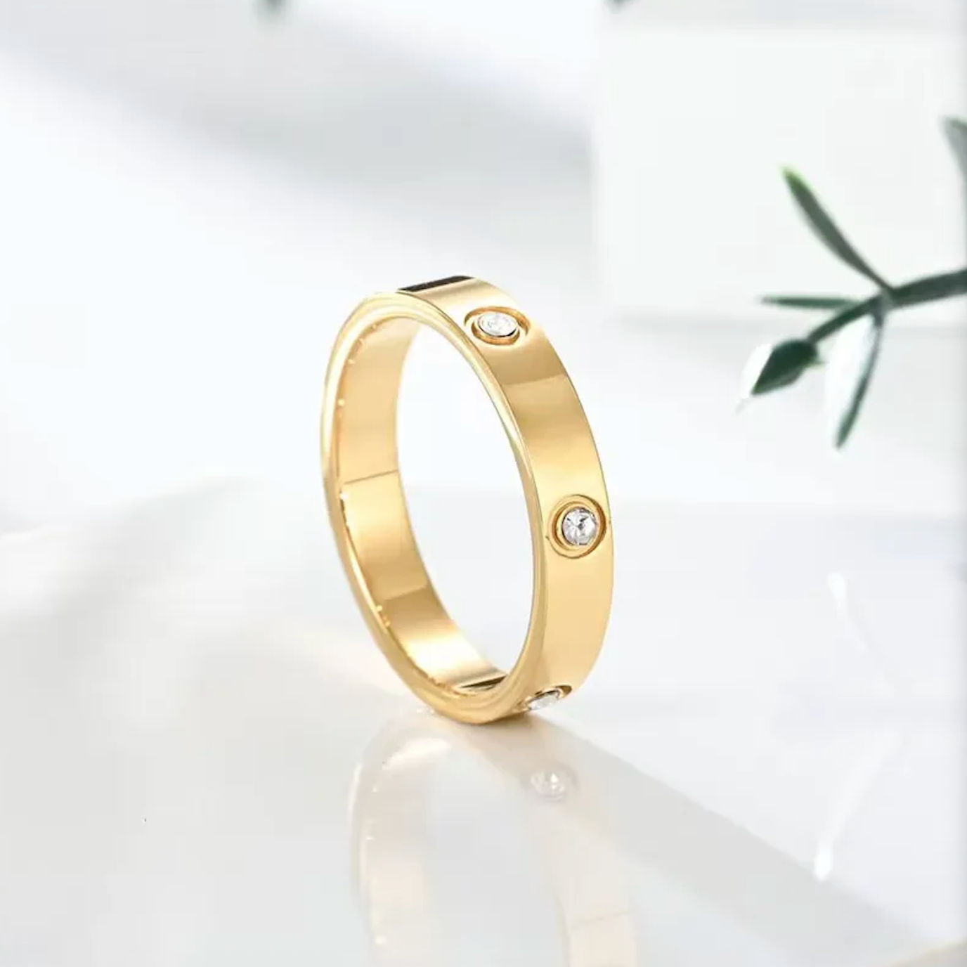 Gold ring with embedded diamonds on a light background