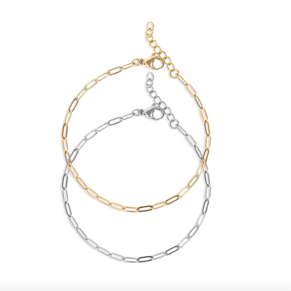 Two chain bracelets, one gold and one silver, on a white background.