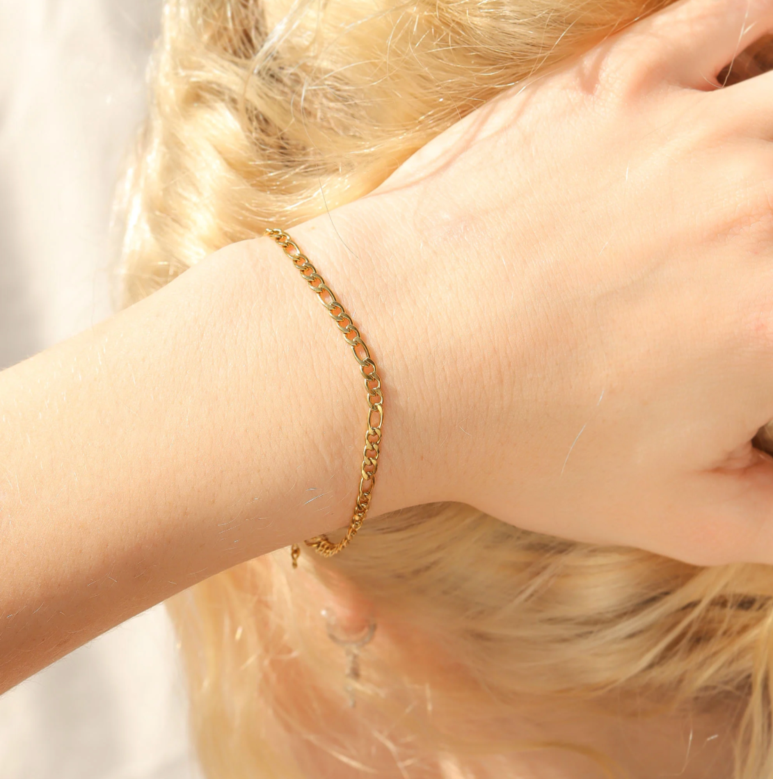 Gold bracelet on a person's wrist with a soft background