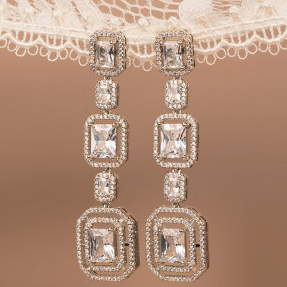 Diamond earrings on a lace fabric background