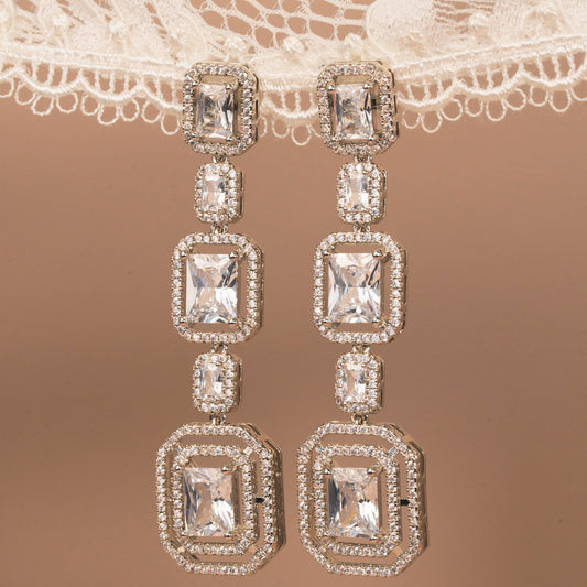 Diamond earrings on a lace fabric background