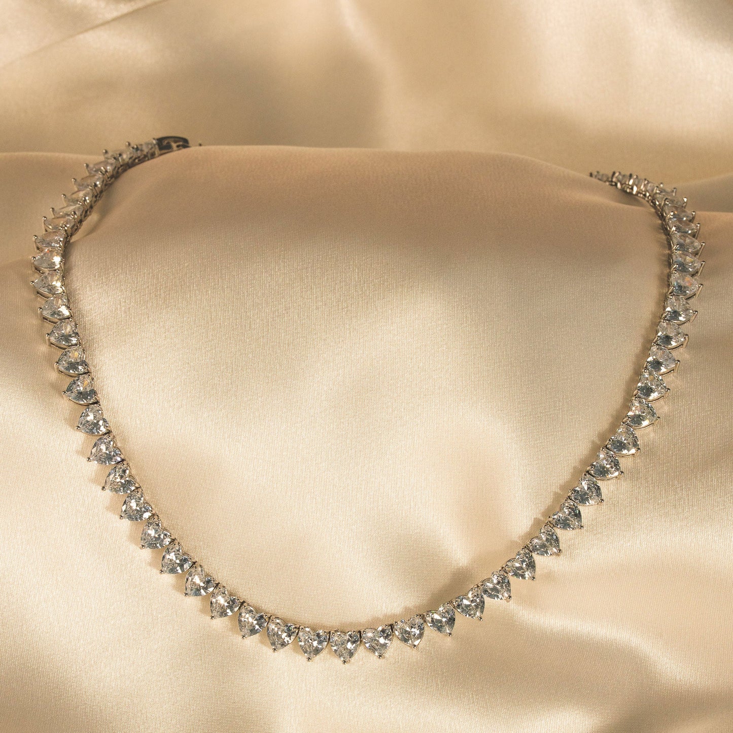 Diamanté necklace on a beige satin background