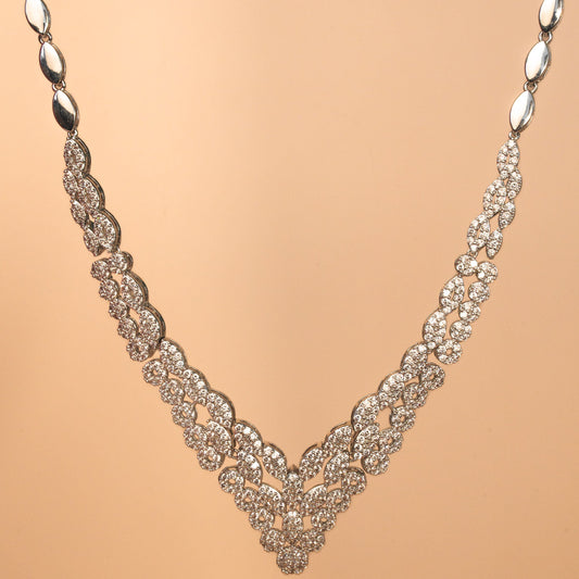 Silver necklace with intricate design on a beige background