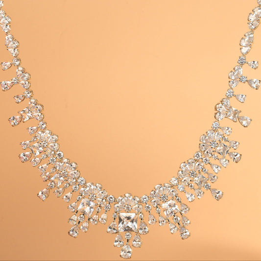 Elegant silver necklace with clear stones on a beige background