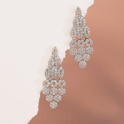 Pair of diamond earrings on a gradient background
