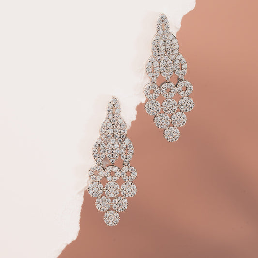 Pair of diamond earrings on a gradient background
